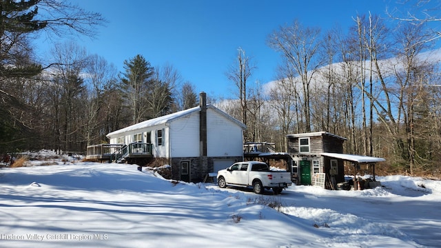 view of snow covered exterior with a wooden deck