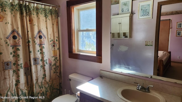 bathroom with toilet, curtained shower, and vanity