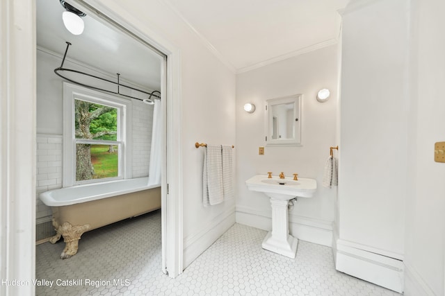 bathroom with tile patterned floors, a bath, and ornamental molding