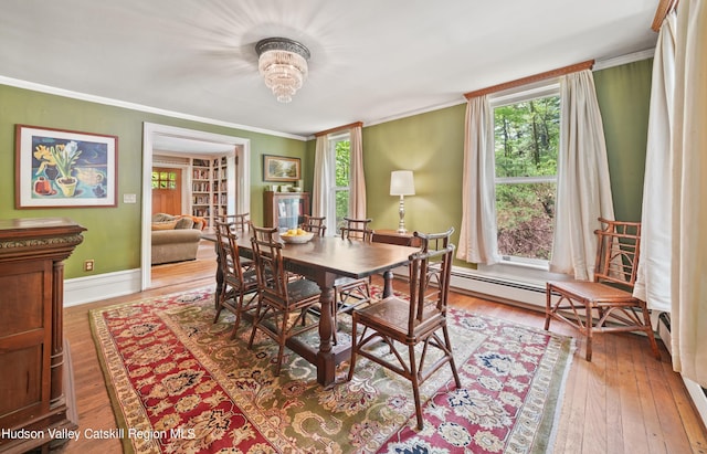 dining area featuring hardwood / wood-style flooring, a notable chandelier, and crown molding