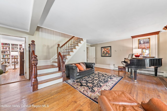 living room with wood-type flooring, a baseboard radiator, and crown molding