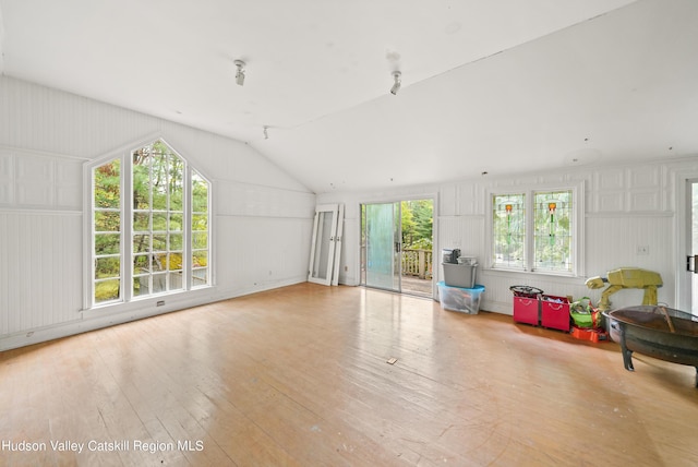 living room featuring plenty of natural light, light hardwood / wood-style floors, and lofted ceiling