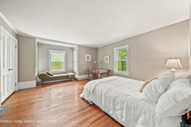 bedroom with ornamental molding and light hardwood / wood-style flooring