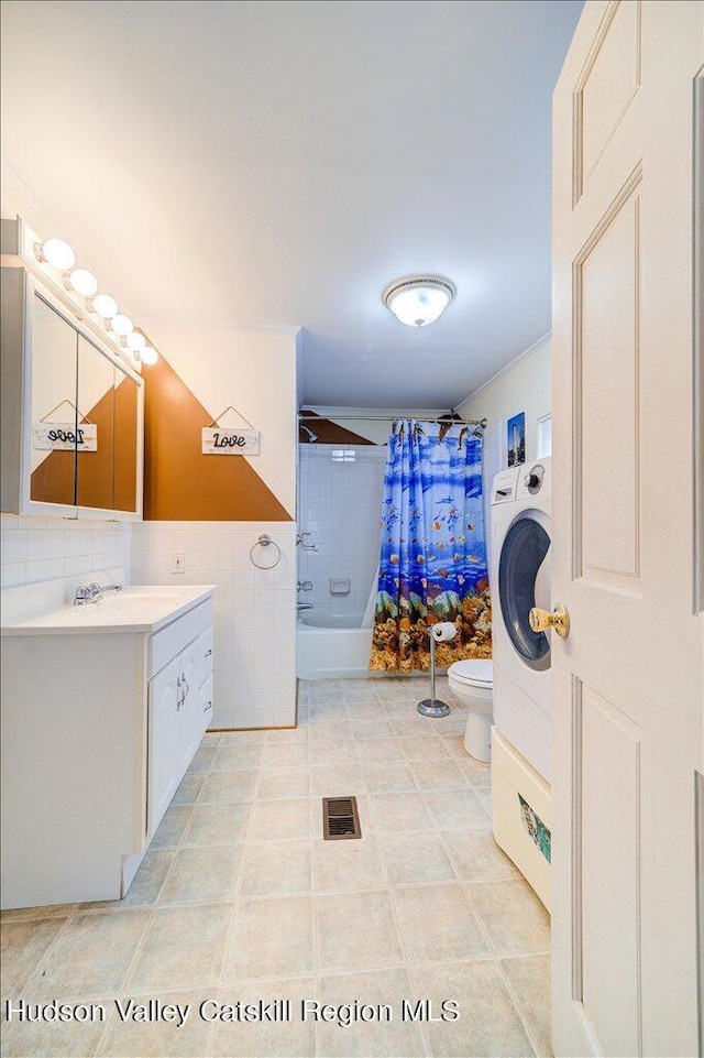 full bathroom with tile patterned floors, vanity, shower / bathtub combination with curtain, washer / dryer, and toilet