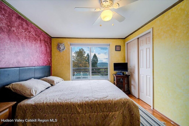 bedroom featuring a closet, ceiling fan, crown molding, and wood-type flooring