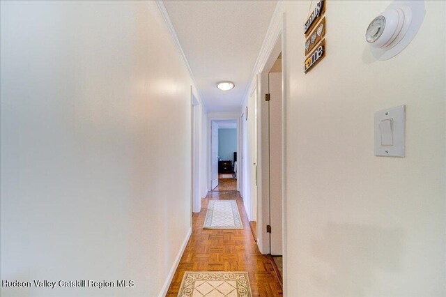 corridor with crown molding and light parquet flooring