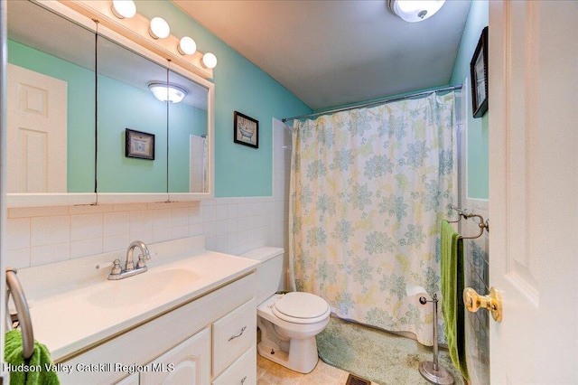 bathroom with a shower with curtain, vanity, toilet, and tile walls