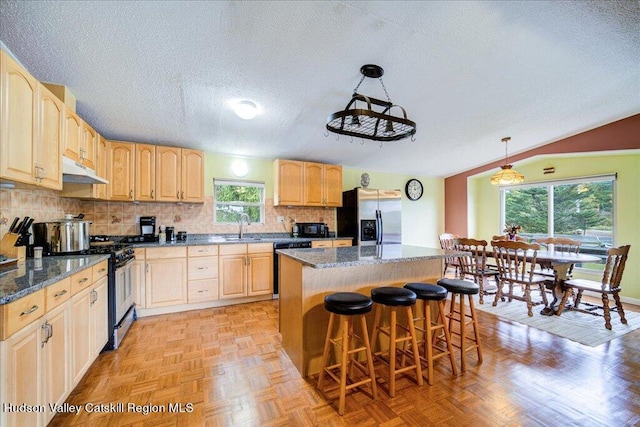 kitchen featuring a wealth of natural light, pendant lighting, a kitchen island, and stainless steel appliances