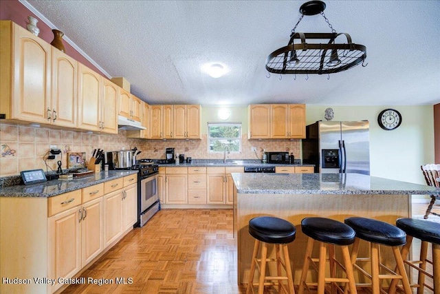 kitchen featuring a breakfast bar area, a kitchen island, black appliances, and a textured ceiling