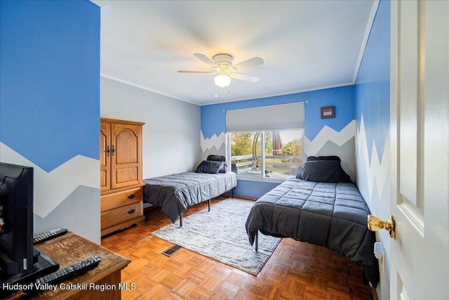 bedroom with ceiling fan, crown molding, and light parquet flooring