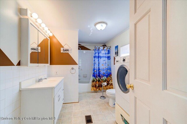 full bathroom featuring washer / clothes dryer, toilet, shower / tub combo with curtain, vanity, and tile walls