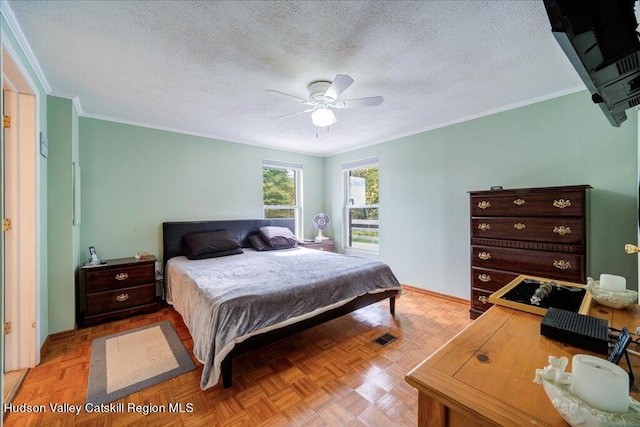 bedroom with ceiling fan, ornamental molding, a textured ceiling, and light parquet flooring