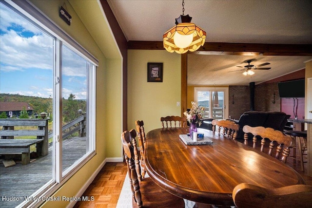 dining space featuring parquet floors, a textured ceiling, ceiling fan, lofted ceiling with beams, and a wood stove