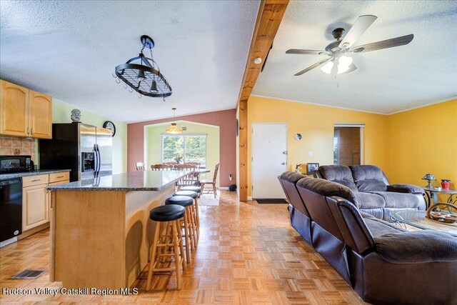 kitchen with a center island, black appliances, lofted ceiling with beams, hanging light fixtures, and light parquet flooring