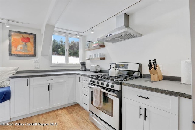 21 Schroon Hill Rd, Kerhonkson, NY 12446 - kitchen featuring stainless steel gas range oven, wall chimney range hood, light wood-style flooring, rail lighting, and white cabinetry