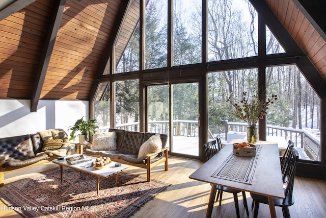 living room featuring a high ceiling, hardwood / wood-style floors, wooden ceiling, and beam ceiling