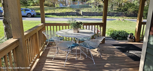 wooden terrace featuring a yard