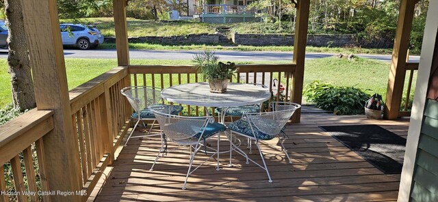 wooden terrace featuring a yard