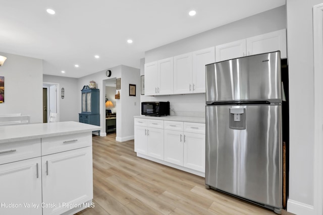 kitchen featuring white cabinetry, stainless steel refrigerator, and light hardwood / wood-style flooring