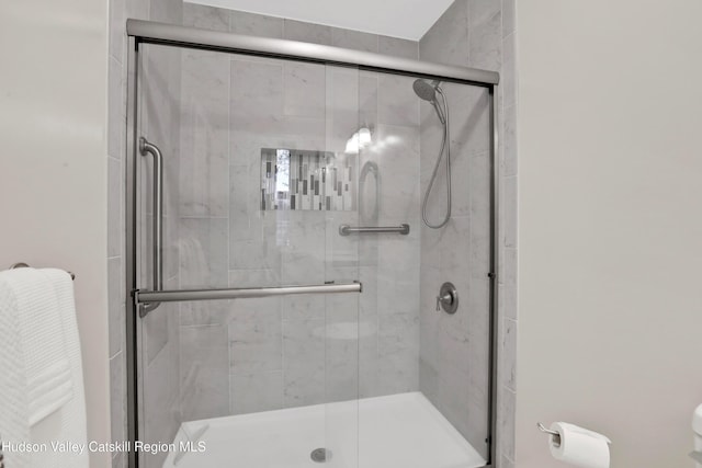 bathroom with a shower with door