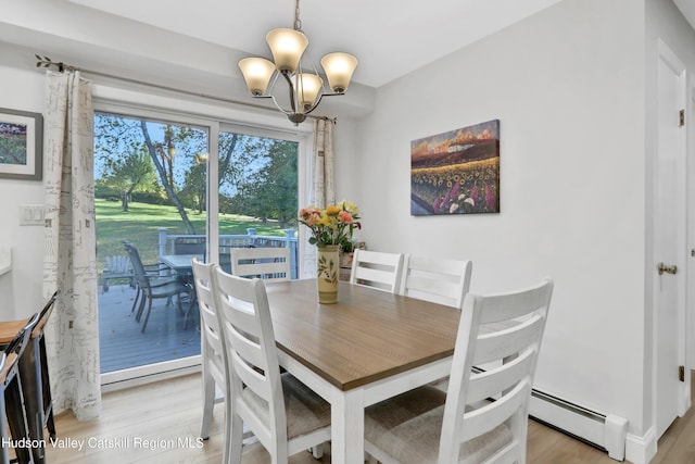 dining space with a notable chandelier, a baseboard heating unit, and light hardwood / wood-style flooring