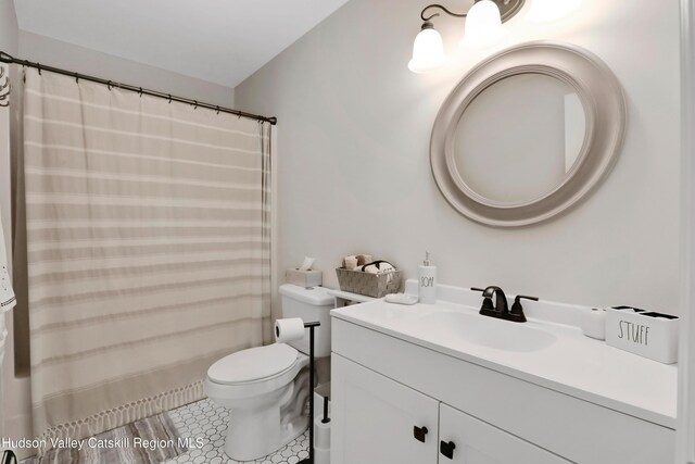 bathroom featuring tile patterned floors, vanity, and toilet