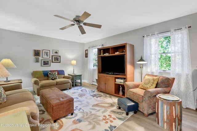 living room with ceiling fan, a wealth of natural light, and light hardwood / wood-style flooring