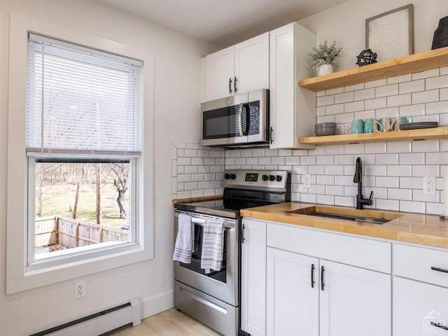 7614 Main St, Hunter, NY 12444 - kitchen with appliances with stainless steel finishes, a sink, baseboard heating, open shelves, and tasteful backsplash