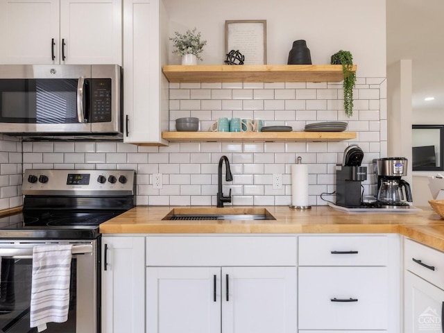 7614 Main St, Hunter, NY 12444 - kitchen with open shelves, appliances with stainless steel finishes, a sink, and backsplash