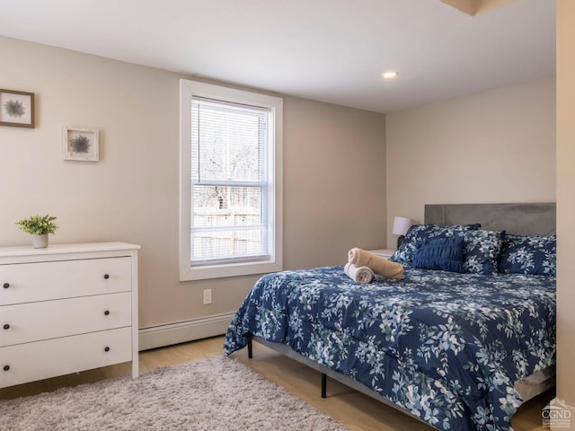 7614 Main St, Hunter, NY 12444 - bedroom with a baseboard heating unit, wood finished floors, and baseboards