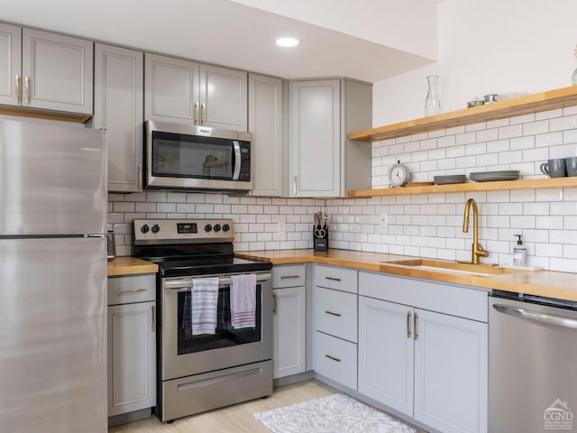 7614 Main St, Hunter, NY 12444 - kitchen with stainless steel appliances, gray cabinets, butcher block countertops, open shelves, and recessed lighting