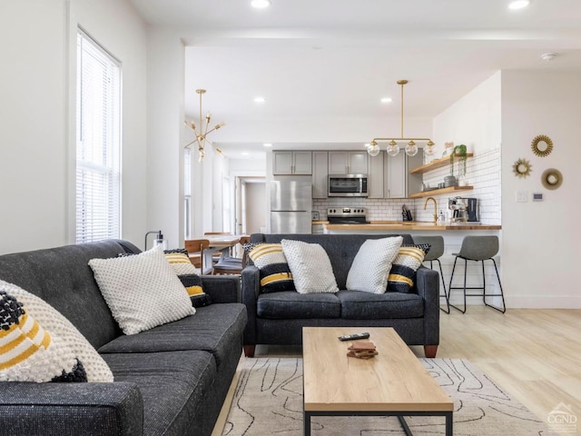 7614 Main St, Hunter, NY 12444 - living area with light wood finished floors, recessed lighting, baseboards, and a chandelier