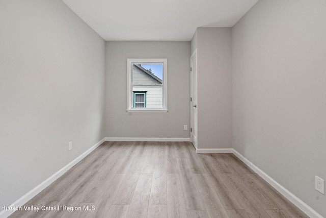 spare room with wood finished floors and baseboards