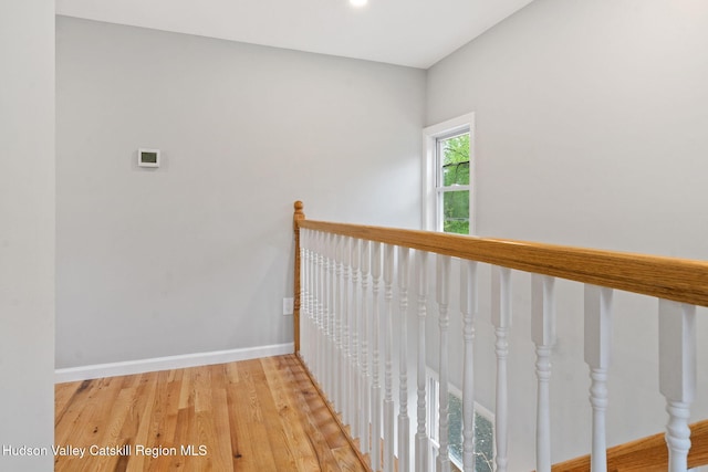 corridor with wood finished floors, baseboards, and recessed lighting