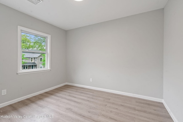 spare room with light wood-style flooring and baseboards