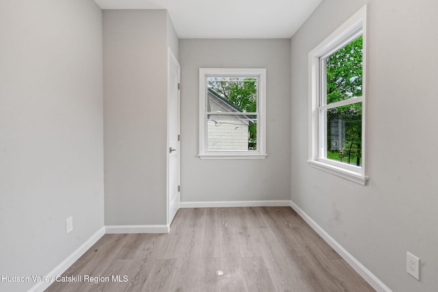 empty room featuring light wood-style flooring and baseboards