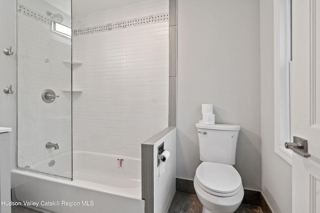 bathroom featuring baseboards, toilet, and shower / tub combination
