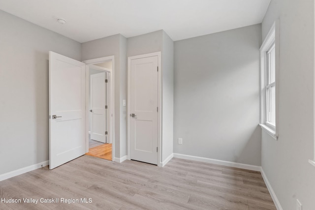 unfurnished bedroom featuring light wood-style floors and baseboards