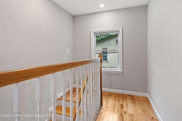 hall with light wood-type flooring, baseboards, and recessed lighting