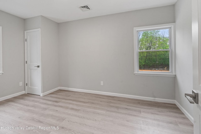 spare room with light wood-style flooring and baseboards