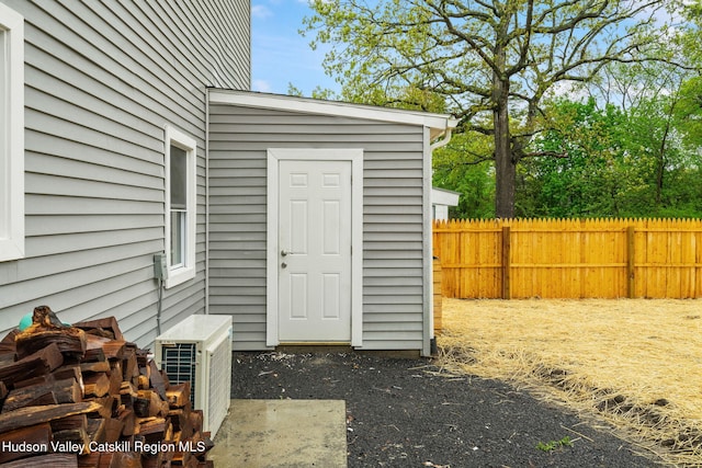 view of outbuilding featuring fence and a cooling unit
