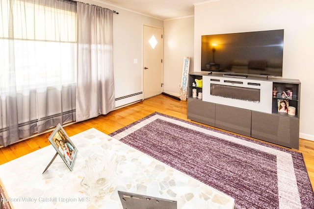 living room with ornamental molding, a baseboard heating unit, and wood finished floors