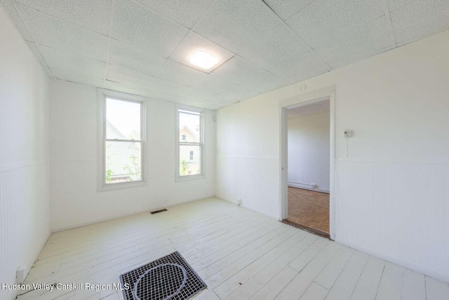 9 Hasbrouck Pl, Kingston, NY 12401 - spare room featuring wood finished floors, wainscoting, and a drop ceiling