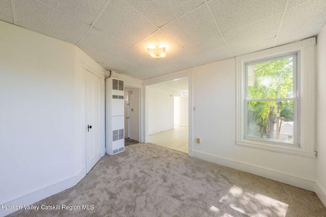 9 Hasbrouck Pl, Kingston, NY 12401 - carpeted empty room featuring a heating unit, a paneled ceiling, and baseboards