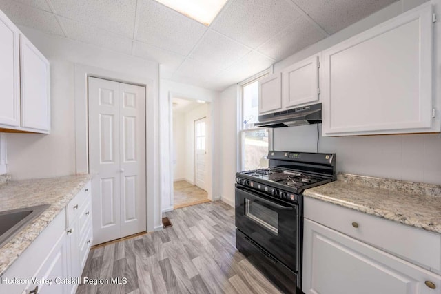 9 Hasbrouck Pl, Kingston, NY 12401 - kitchen featuring gas stove, under cabinet range hood, white cabinetry, light wood-type flooring, and a paneled ceiling