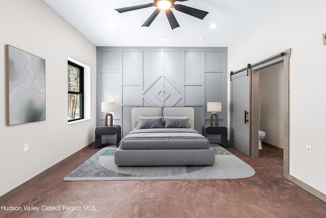 bedroom with ceiling fan and a barn door