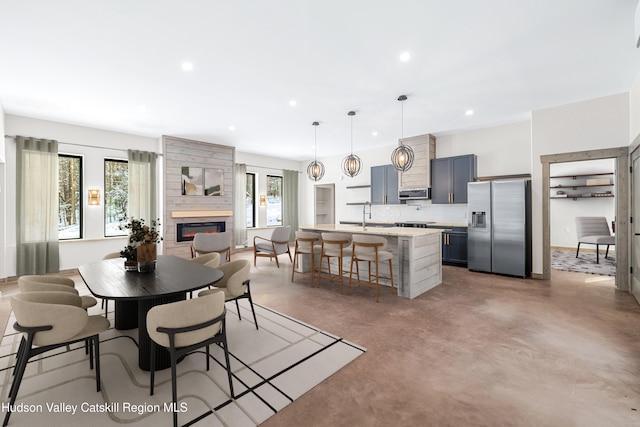 dining area with sink, a wealth of natural light, and a large fireplace