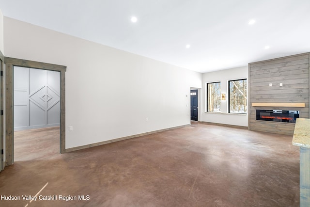 unfurnished living room with a large fireplace and concrete floors