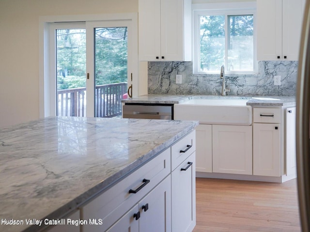 16 Trinity Pl, Rhinebeck, NY 12572 - kitchen with a sink, light stone counters, backsplash, and white cabinetry