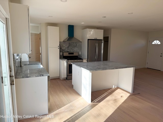 16 Trinity Pl, Rhinebeck, NY 12572 - kitchen featuring wall chimney range hood, stainless steel appliances, a sink, light wood-style flooring, and decorative backsplash